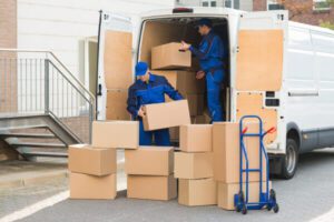 workers loading items packed within boxes into truck