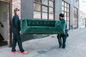 Household Items Removal Services | Junk-collector 2 two men holding green sofa and moving it from one place to another